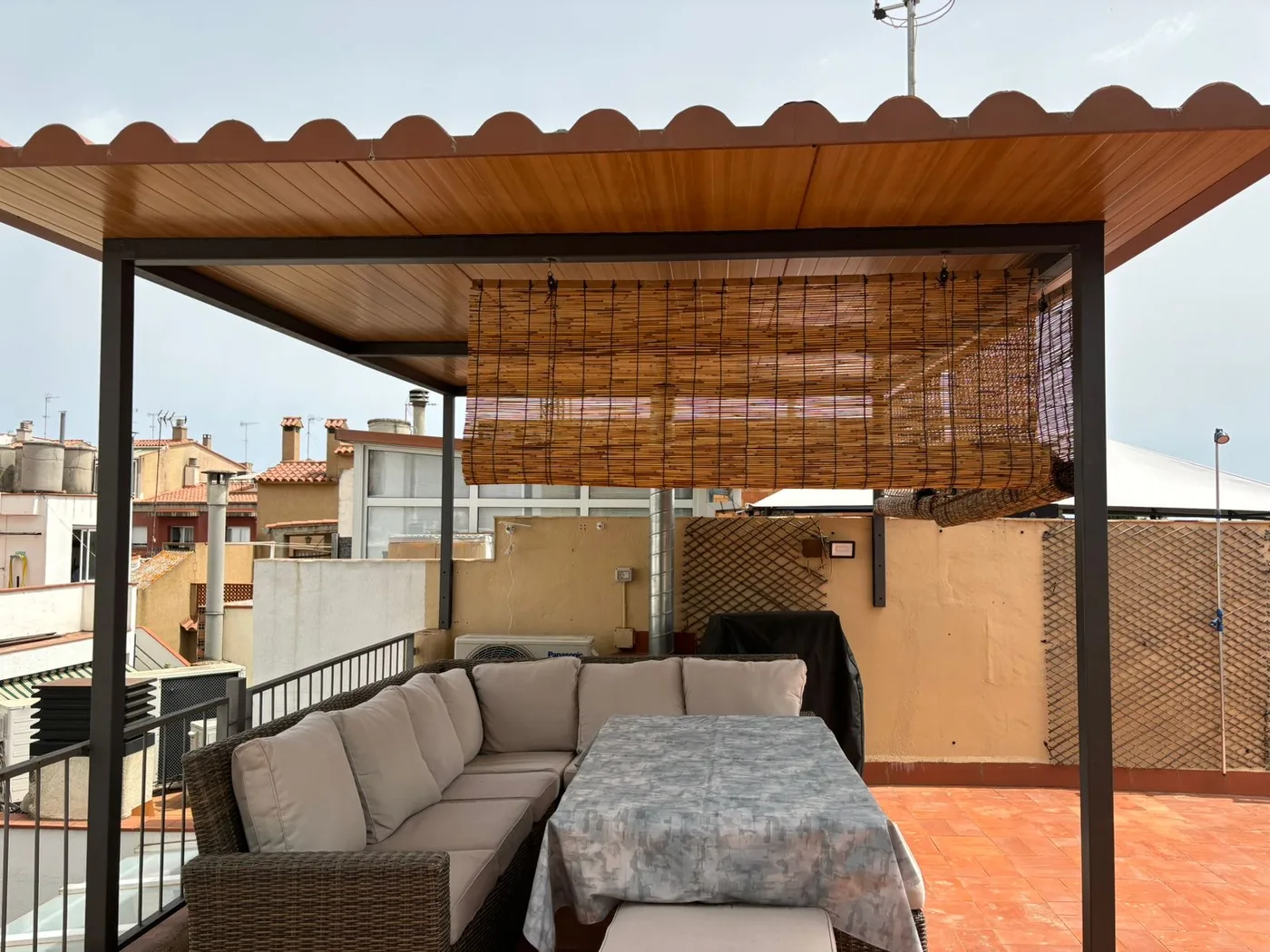 Pèrgola exterior amb estructura metàl·lica i coberta de fusta